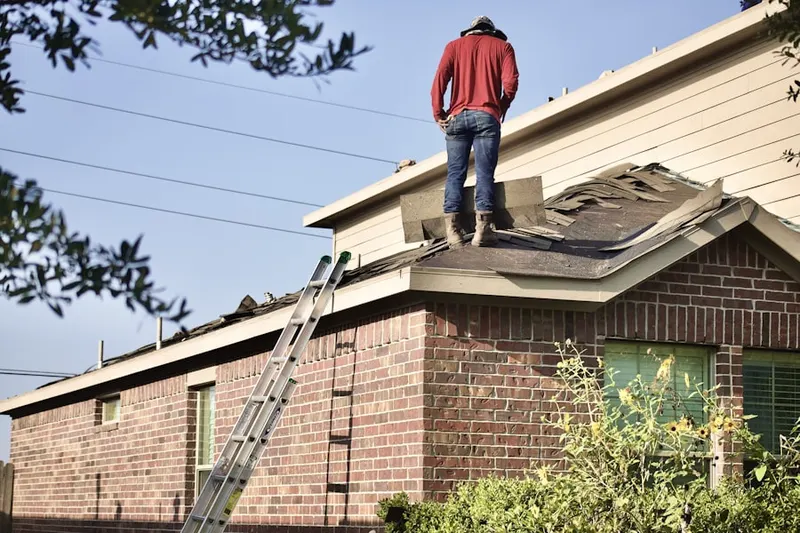 Professional roofer working on a residential roof in Westport